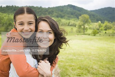 Portrait of a girl hugging her mother from behind