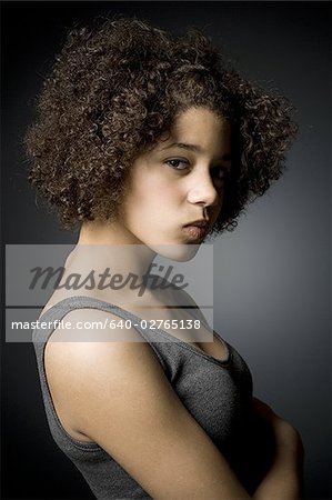 Teenage girl standing with arms crossed