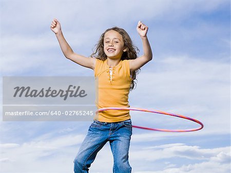 Fille jouant avec le hula hoop en riant à l'extérieur