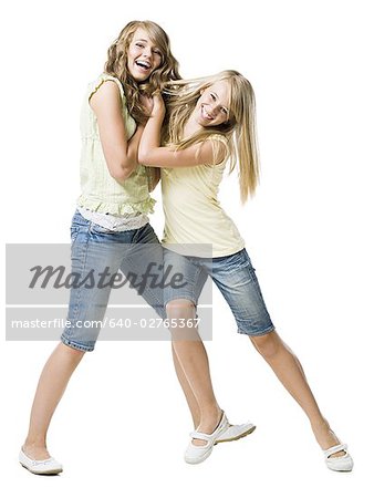 Two girls play fighting and smiling