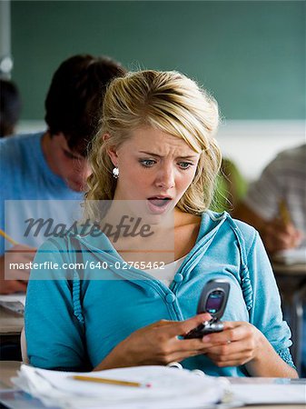 Girl looking at mobile phone in class.