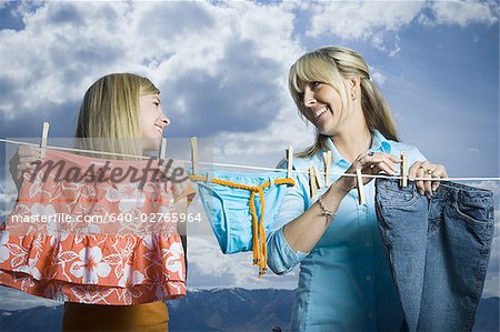 Gros plan d'une mère et sa fille regardant les uns les autres et sourire tout en faisant la lessive