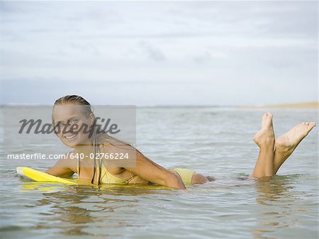 Portrait of a teenage girl floating on a boogie board in the sea