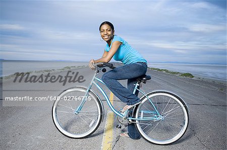 Portrait d'une jeune femme assise sur un vélo