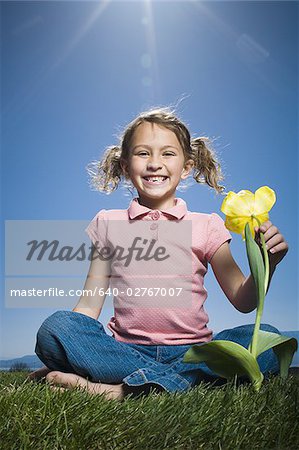 Portrait of a girl sitting beside a flower