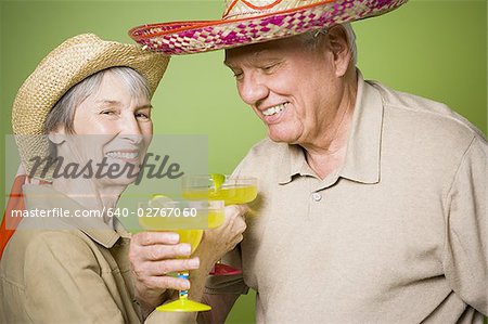 Portrait d'un couple de personnes âgées tenant des verres de jus de citron