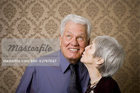 Close-up of an elderly woman kissing an elderly man