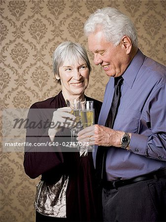 Portrait d'un couple de personnes âgées tenant des verres de vin