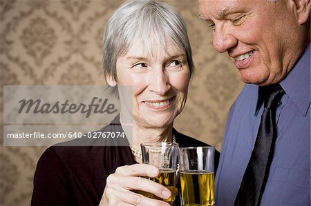 Portrait d'un couple de personnes âgées tenant des verres de vin