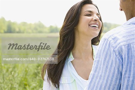 Close-up of a man and a woman holding hands in a field