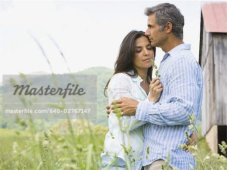 Profile of a man and a woman embracing each other in a field