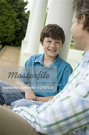 Gros plan d'un garçon et son père souriant