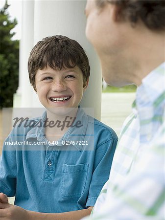 Gros plan d'un garçon et son père souriant