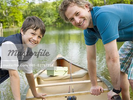 Portrait d'un homme et son fils se penchant vers l'avant sur un canot
