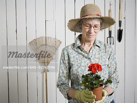 Portrait d'une femme tenant une plante en pot de fleur
