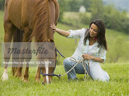 Portrait of a woman holding the reins of a horse