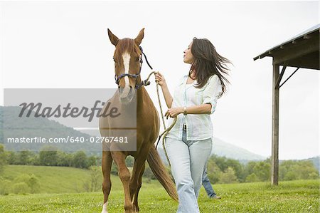 femme qui marche avec un cheval