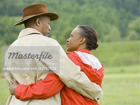Ein alter Mann und einer leitenden Frau ihre Arme umeinander Rückansicht