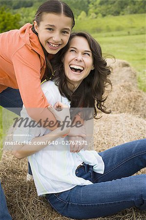 Portrait eines Mädchens, umarmt ihre Mutter von hinten