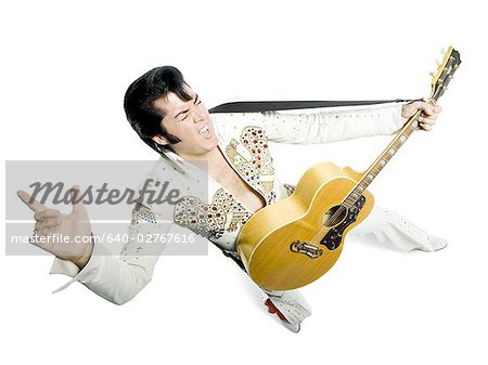 Portrait généraux d'un imitateur d'Elvis tenant une guitare