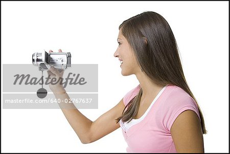 Profil d'une jeune femme tenant un appareil vidéo