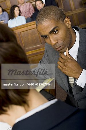 Vue grand angle sur un avocat mâle dans une salle d'audience lors d'un procès