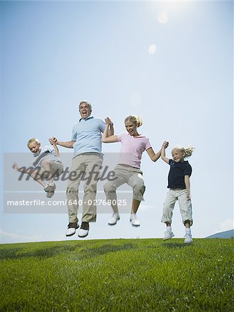 Low angle view of parents and their two children jumping