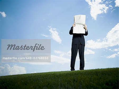 Low angle view of a businessman reading a newspaper
