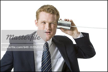 Portrait of a businessman using a tin can phone