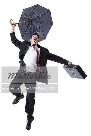 Portrait of a businessman holding an umbrella and jumping