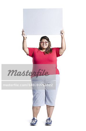 Corpulence jeune femme tenant une pancarte blanche