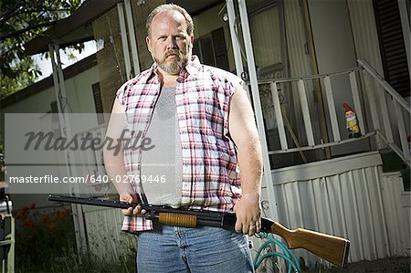 Homme avec un fusil de chasse en surpoids