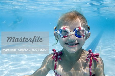 Fille de nager sous l'eau dans la piscine