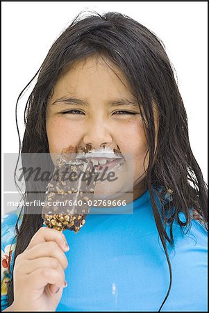 Overweight young girl eating ice cream bar