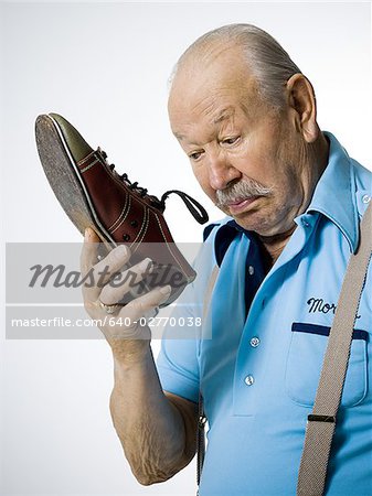 Male bowler sniffing stinky bowling shoes