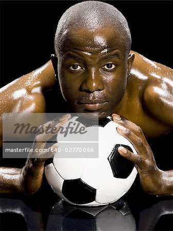 Athlet posiert mit Fußball
