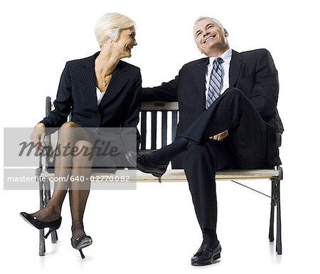 Businessman and businesswoman sitting on a bench