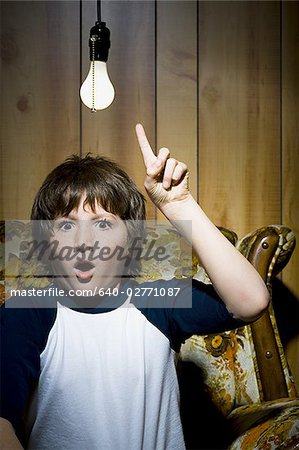 Boy sitting on sofa with light bulb idea