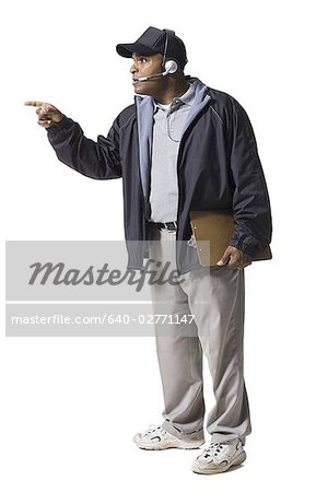 Coach with clipboard and headset pointing