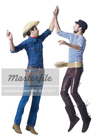 Homme en costume de cow-boy et homme en pantalon de cuir avec ceinture sash high five
