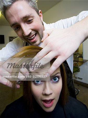 Woman having hair cut by hairdresser