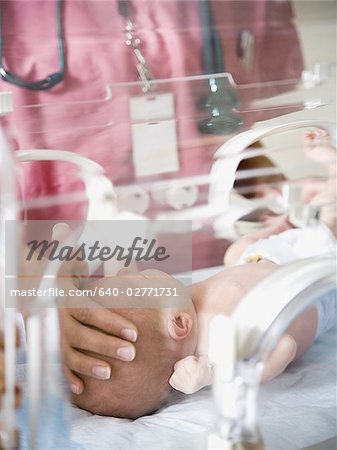Baby in incubator with female nurse