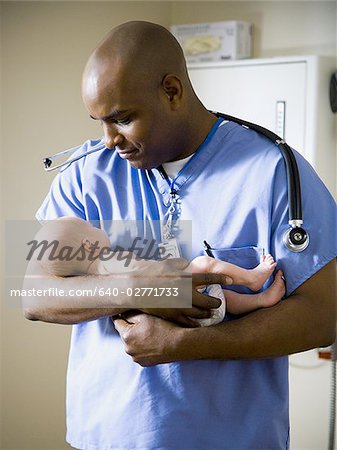 Male nurse or doctor holding newborn baby