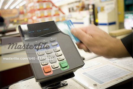 Person swiping debit card at POS machine