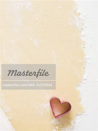 Detailed view of dough with hearts and rolling pin