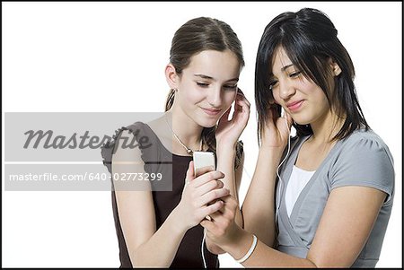 Two girls listening to mp3 player smiling