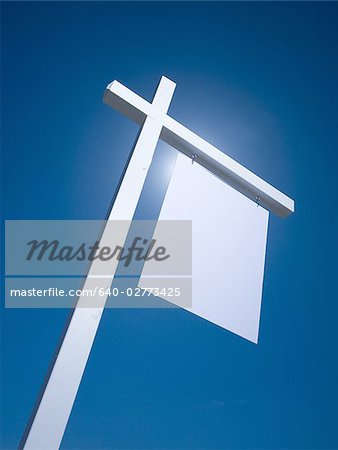 Blank sign hanging outdoors with blue sky