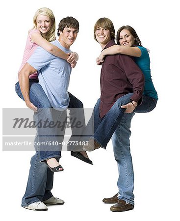 Two boys giving two girls piggy back rides