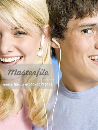 Portrait of a young couple with ear buds smiling