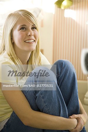 Portrait d'une jeune fille, siégeant en chambre souriant